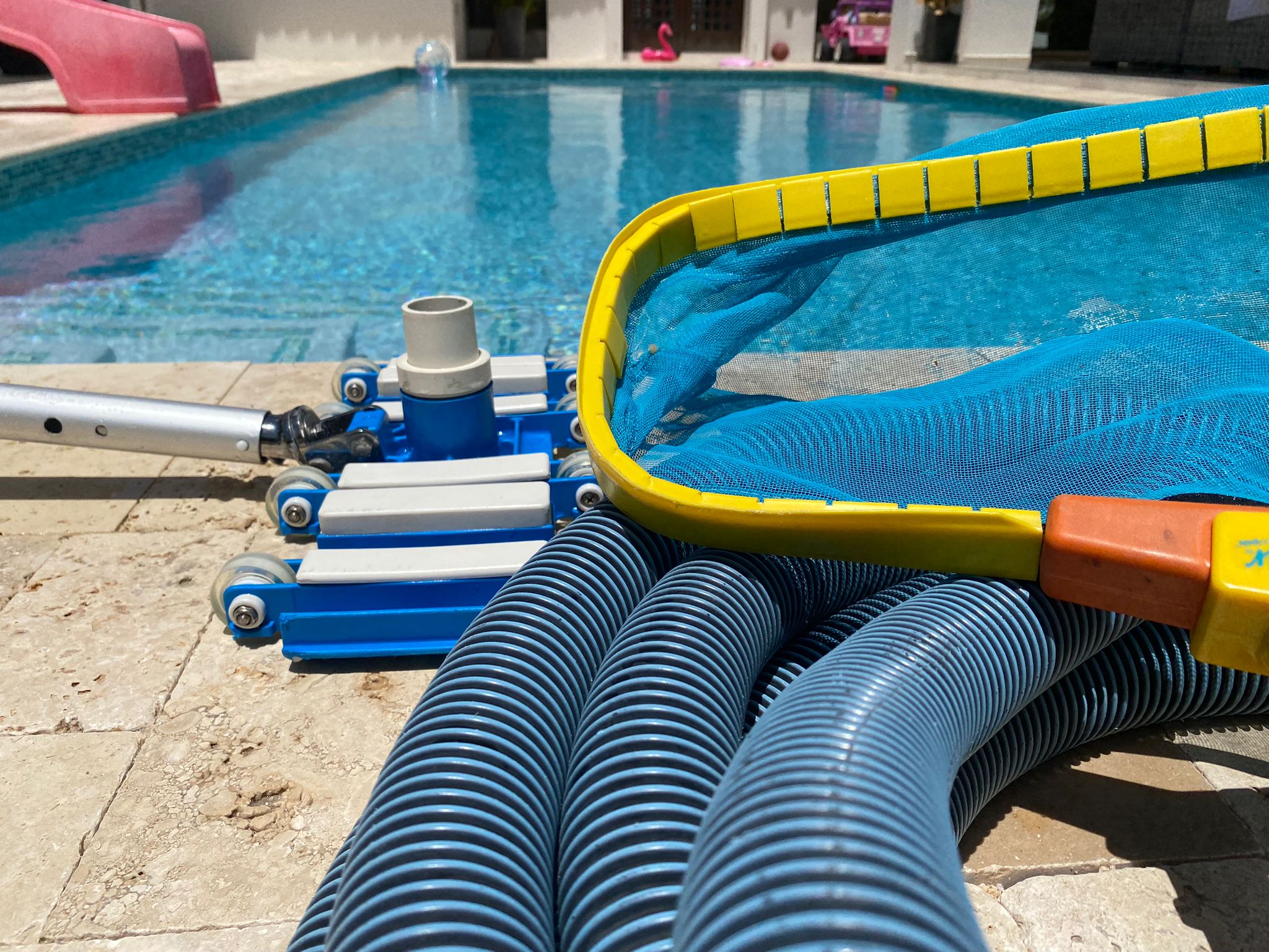 swimming pool cleaning equipment next to pool